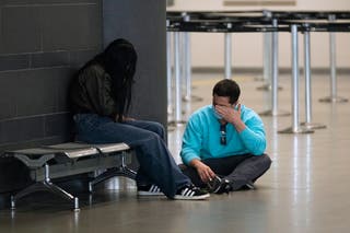 Colombian migrants deported from the United States sit inside El Dorado airport Tuesday